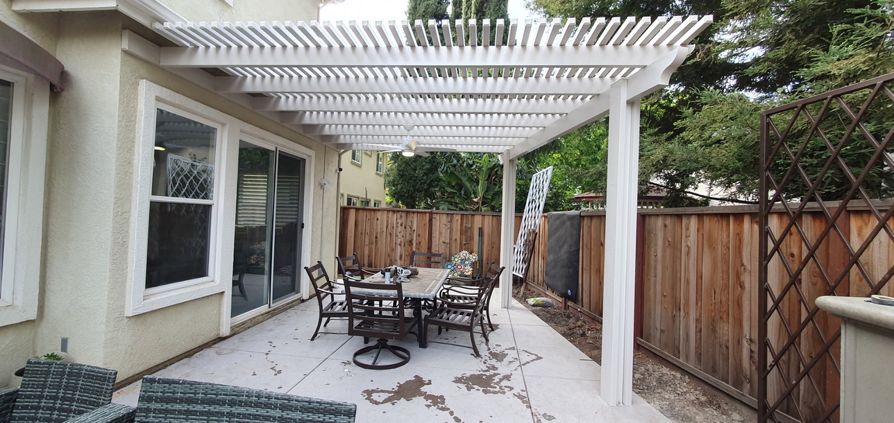 Backyard patio with custom white lattice pergola patio cover and outdoor dining set